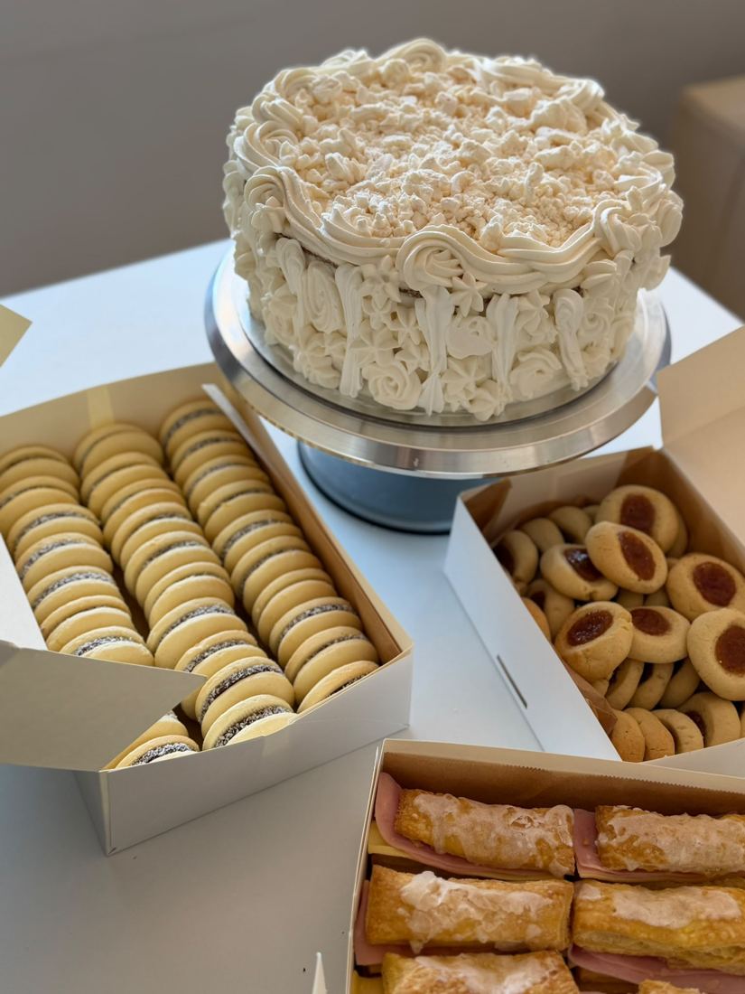 Mesa de evento con pastel, alfajores y fosforitos