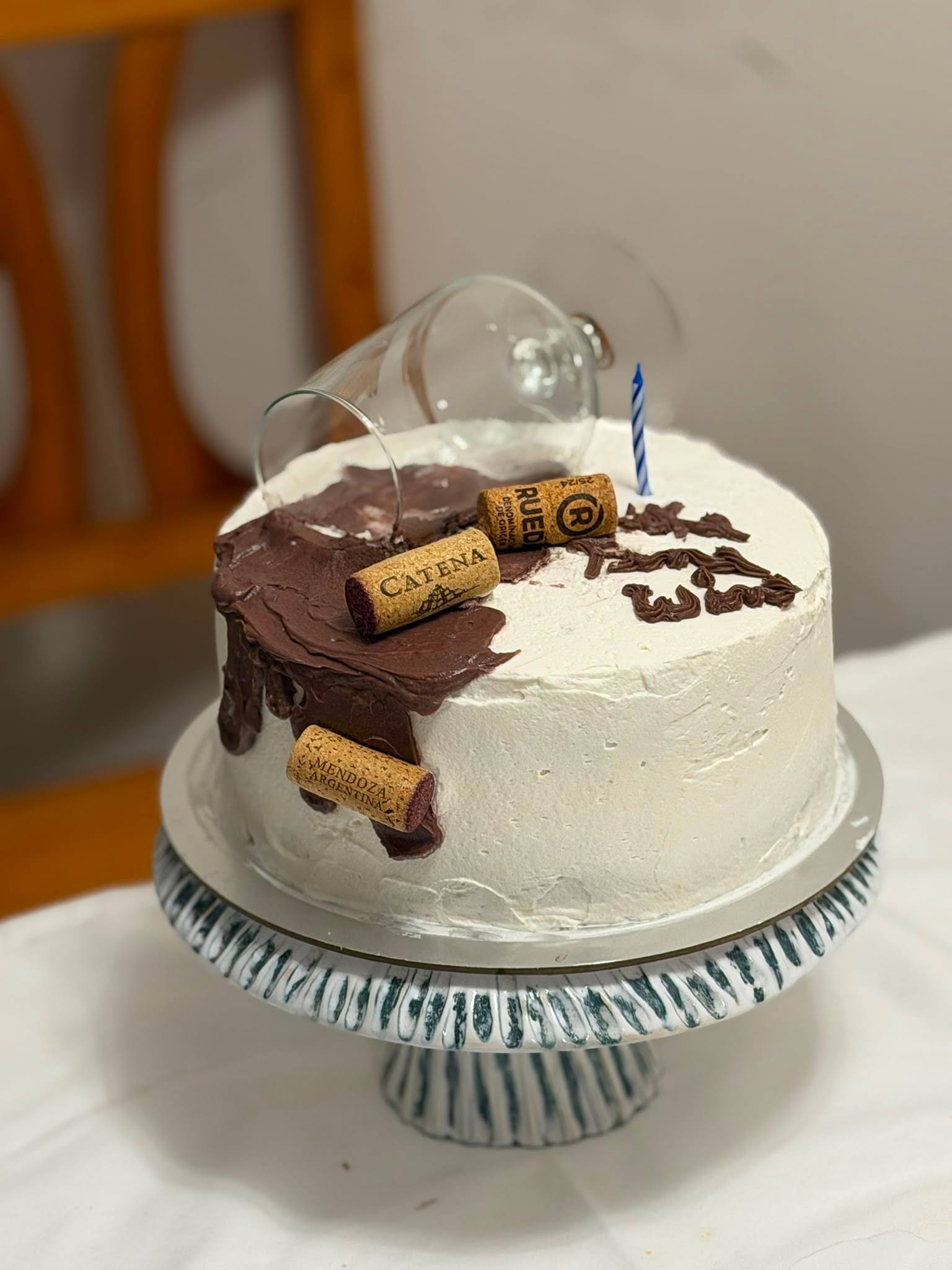 Pastel blanco decorado con copa y corchos de vino